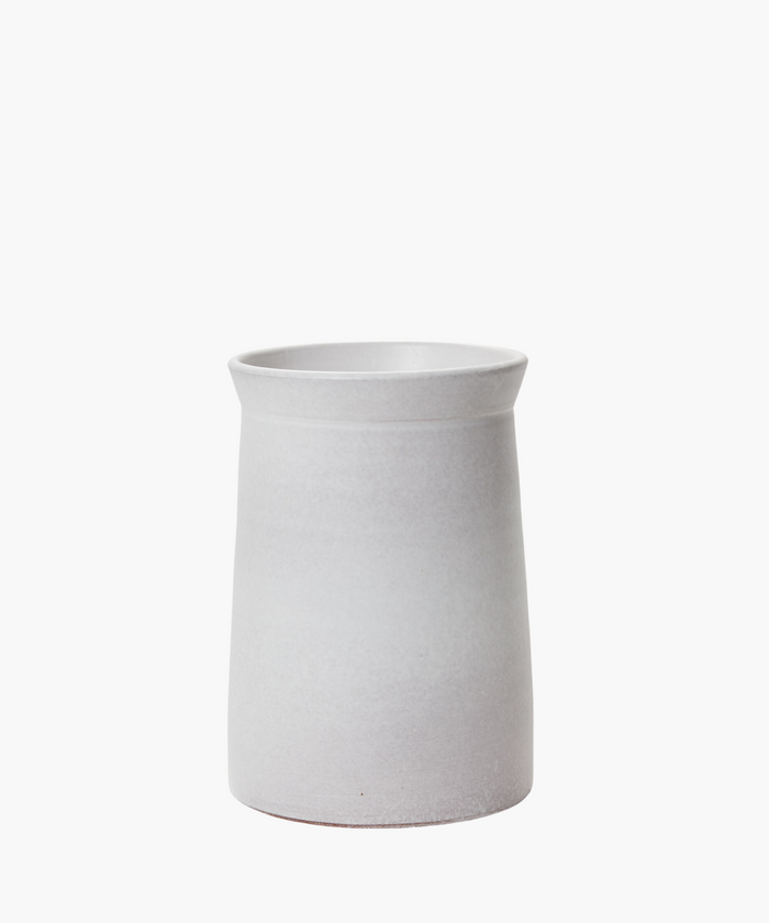 A minimalist, cylindrical white ceramic vase with a slightly flared rim against a plain white background, conveying simplicity and elegance. | Wildwood Home Co.