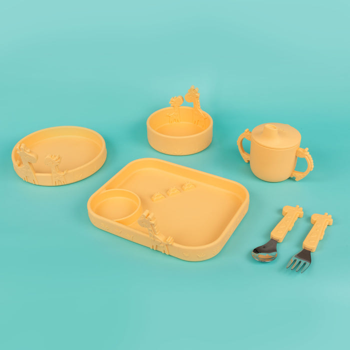 A yellow children’s dining set with playful giraffe designs, featuring a sectioned plate, two bowls, a sippy cup with handles, a spoon, and a fork—all displayed on a cheerful turquoise background.