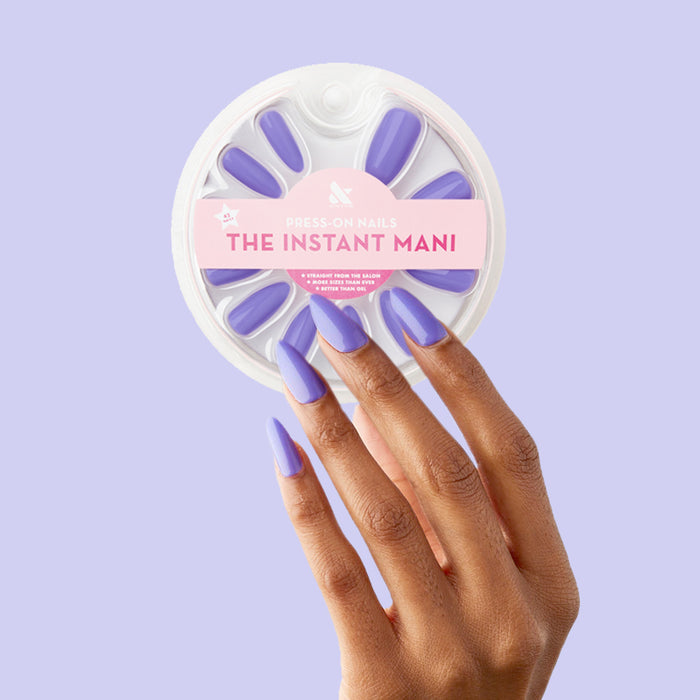 Bold & Unshaken - Press-On | Long | Almond showing hand with long almond press-on nails in bold purple polish holding nail set