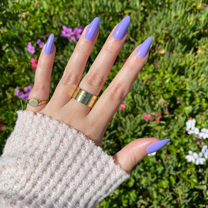 Bold & Unshaken - Press-On | Long | Almond showing hand with long violet almond press-on nails outdoors with textured sweater sleeve