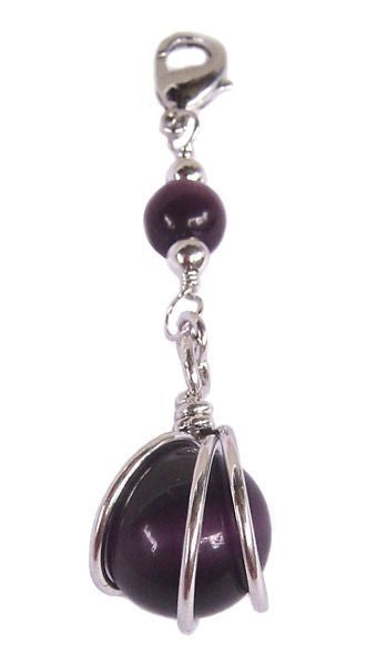 Close-up of silver ball hair charm with deep purple bead detail