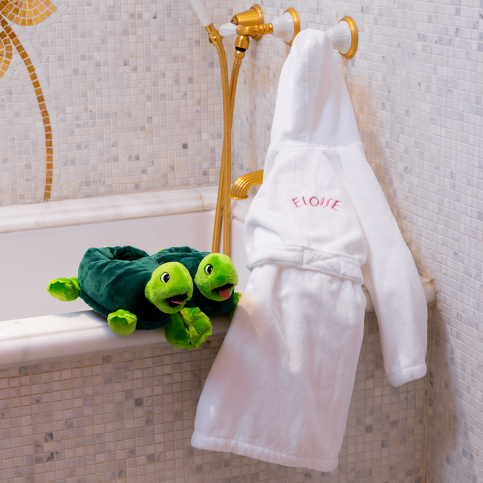 Eloise hooded children's bathrobe next to a pair of Skiperdee bath slippers