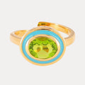 a gold ring with a green stone in the middle