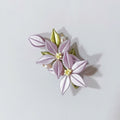 Chanhua handmade lavender bellflower hair accessory with two blooms, gold-tipped green leaves, and pearl accents, displayed on a light gray background