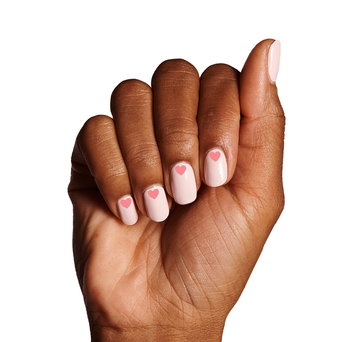 Hand with light pink gel polish nails featuring Heart to Heart small heart nail art stickers by Olive and June