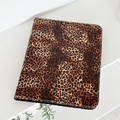 Closed Coconut Lane iPad case with leopard print on a white surface, plant visible nearby.