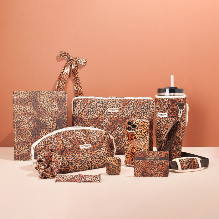 Leopard print iPad case, bags, tumbler, and phone case arranged on a neutral background.