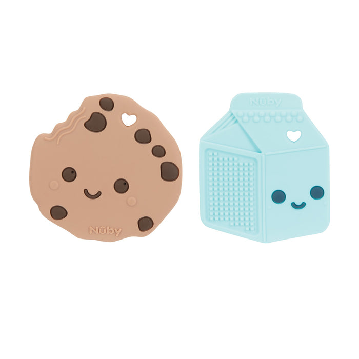 Two silicone baby teethers: one shaped like a chocolate chip cookie with a smiling face, and the other like a light blue milk carton with heart-shaped cutouts. Both are perfect for soothing sore gums.