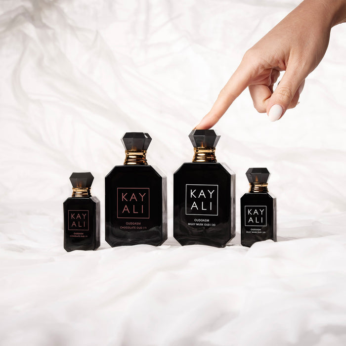 Four black perfume bottles with gold accents labeled 'KAYALI' on a white fabric background.
