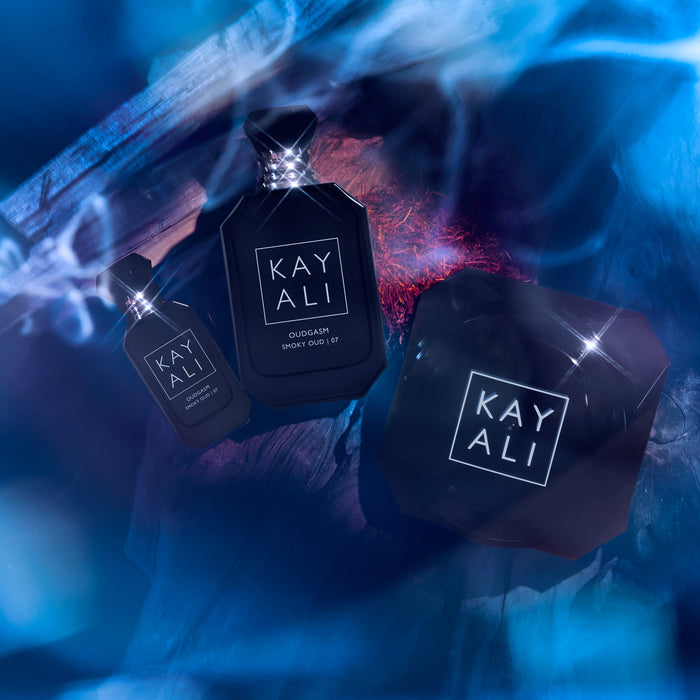 Three black perfume bottles with 'KAYALI' branding on a blue and purple gradient background.