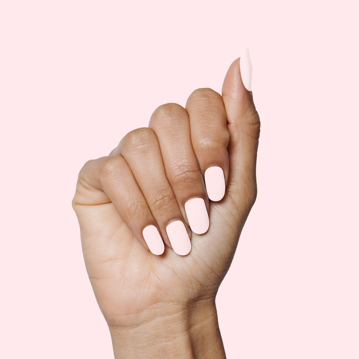 Hand with medium nails painted in soft pink PINK SANDS nail polish for a smooth manicure look