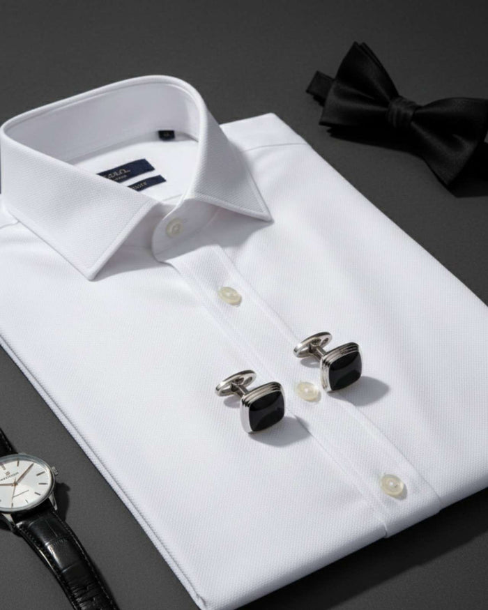 Silver cufflinks with black glossy square cushion fronts on a white dress shirt