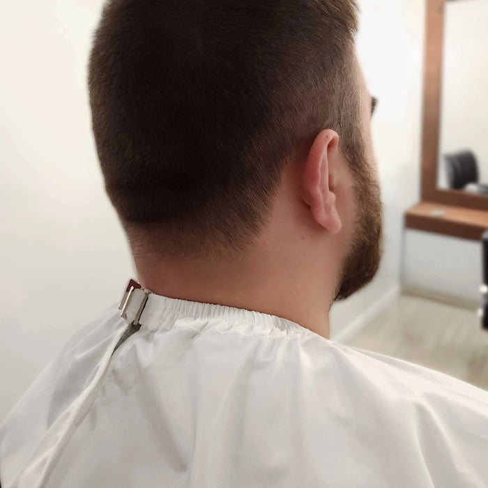 Back view of a person with a haircut in a salon setting