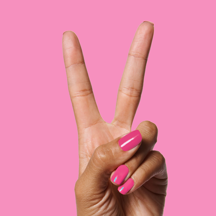 Hand showing two fingers with smooth WILD ORCHID polish manicure in bold magenta against pink background